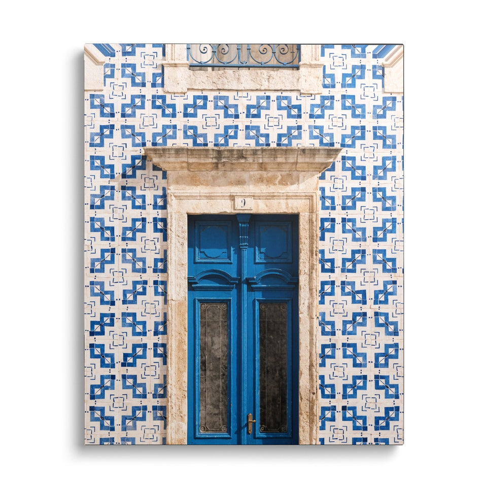 Toile Azulejos vue de face sur fond blanc : photographie d’une façade couverte de carreaux de faïence bleus et blancs, avec une porte bleue