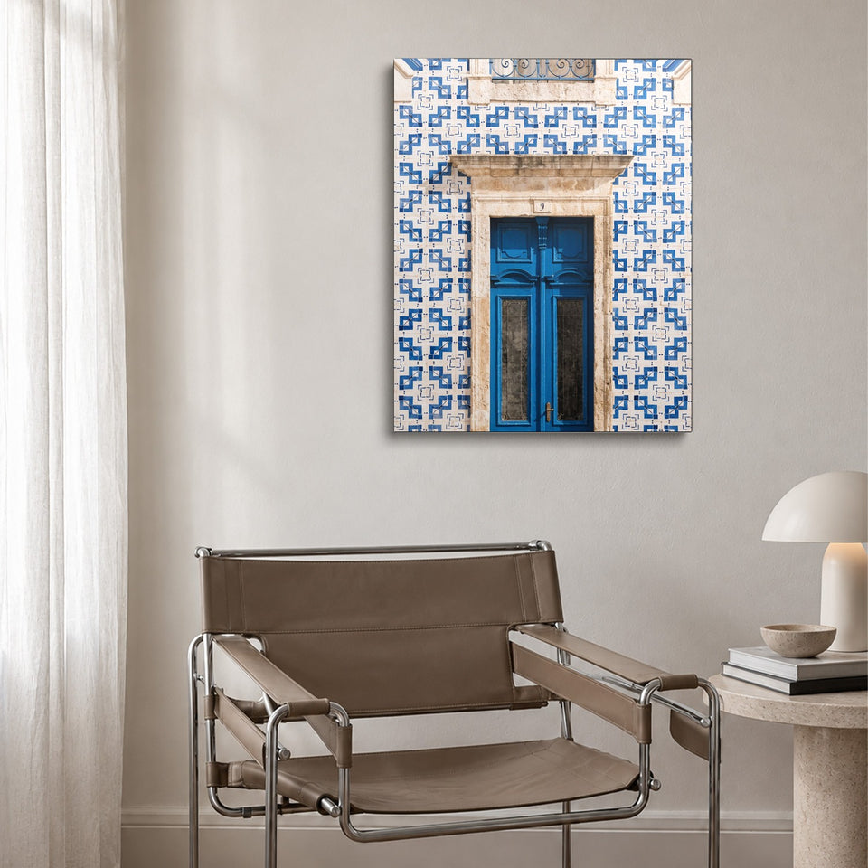 Toile Azulejos accrochée au-dessus d’un fauteuil en cuir et acier