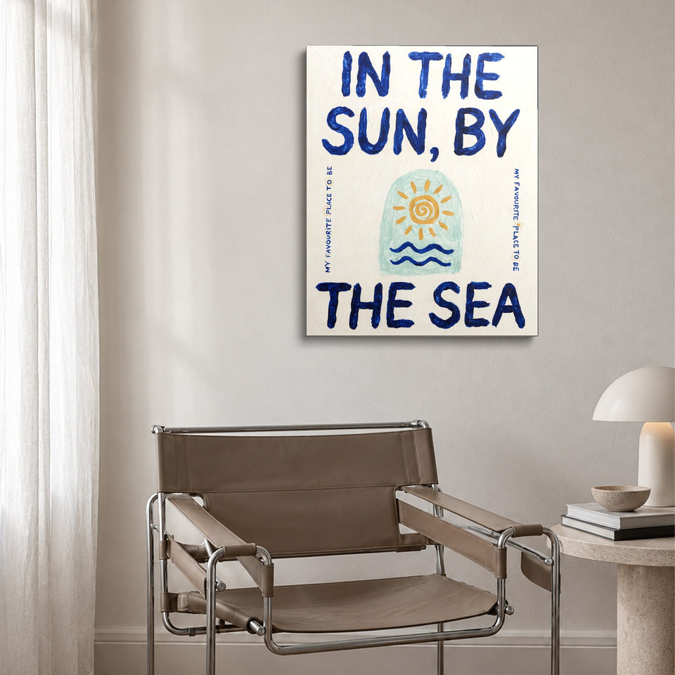Toile By the Sea accrochée au-dessus d’un fauteuil en cuir et acier