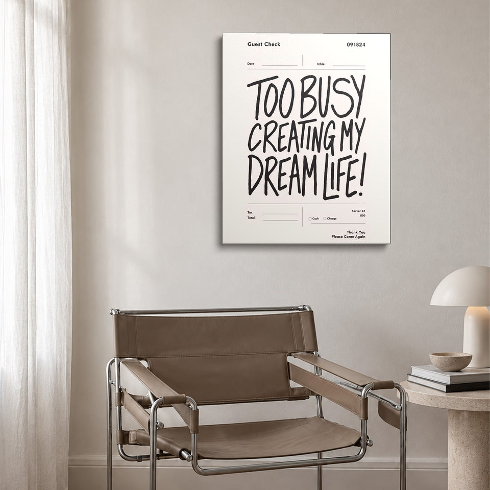 Toile Dream Life accrochée au-dessus d’un fauteuil en cuir et acier
