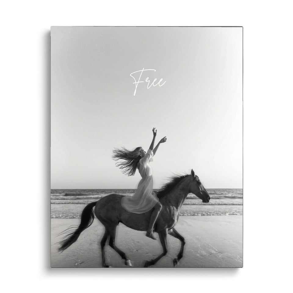 Toile Galop vue de face sur fond blanc : photographie noir et blanc d’une cavalière en robe blanche, bras levés, sur un cheval au galop au bord de la mer