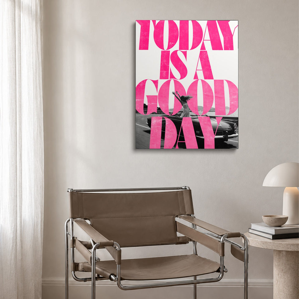 Toile Good Day accrochée au-dessus d’un fauteuil en cuir et acier