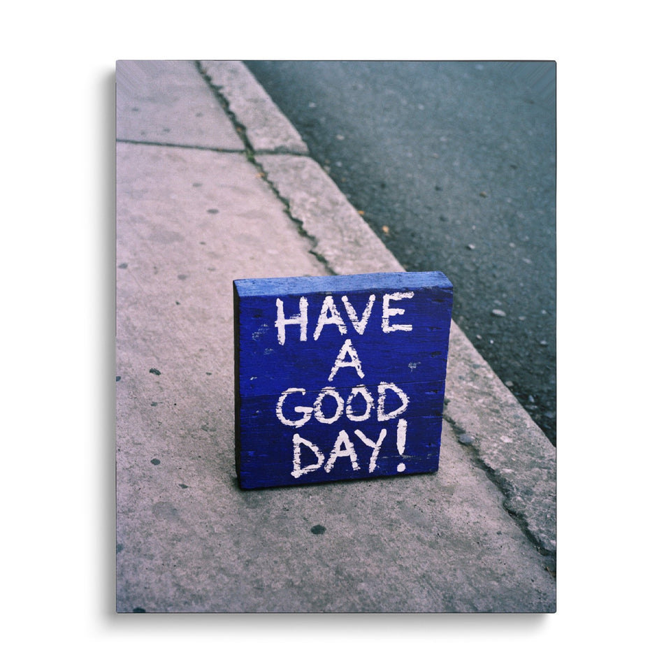 Toile Have a Good Day vue de face sur fond blanc : photographie d’un pavé peint en bleu posé sur un trottoir, avec « Have a good day! » écrit à la main