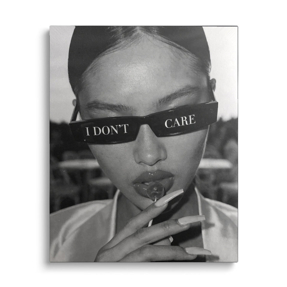 Toile I Don’t Care vue de face sur fond blanc : portrait photographique noir et blanc d’une femme aux lunettes noires marquées « I don’t care », une sucette aux lèvres
