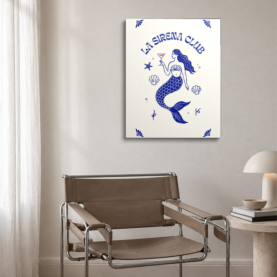 Toile La Sirena Club accrochée au-dessus d’un fauteuil en cuir et acier