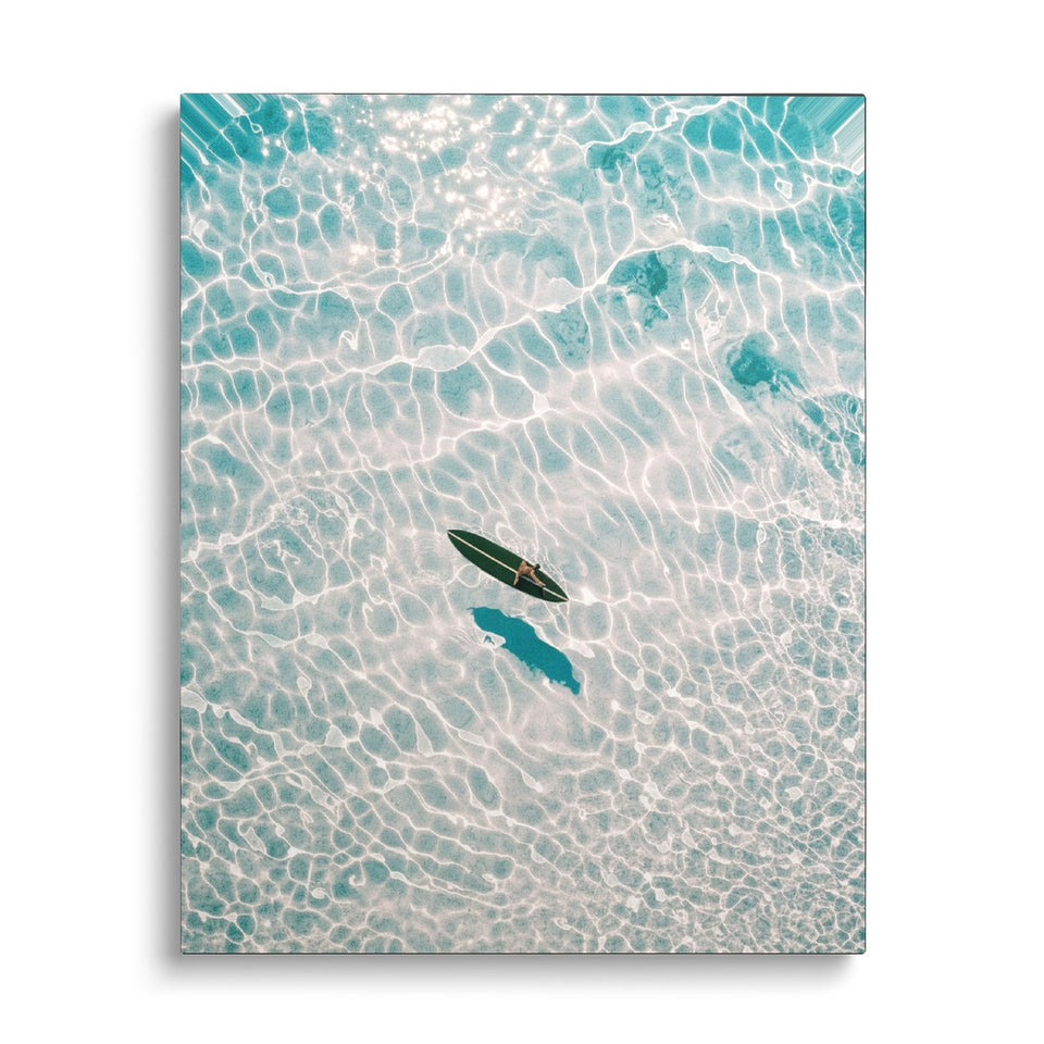 Toile Lagon vue de face sur fond blanc : photographie aérienne d’une planche de surf flottant sur une eau turquoise transparente aux reflets de lumière