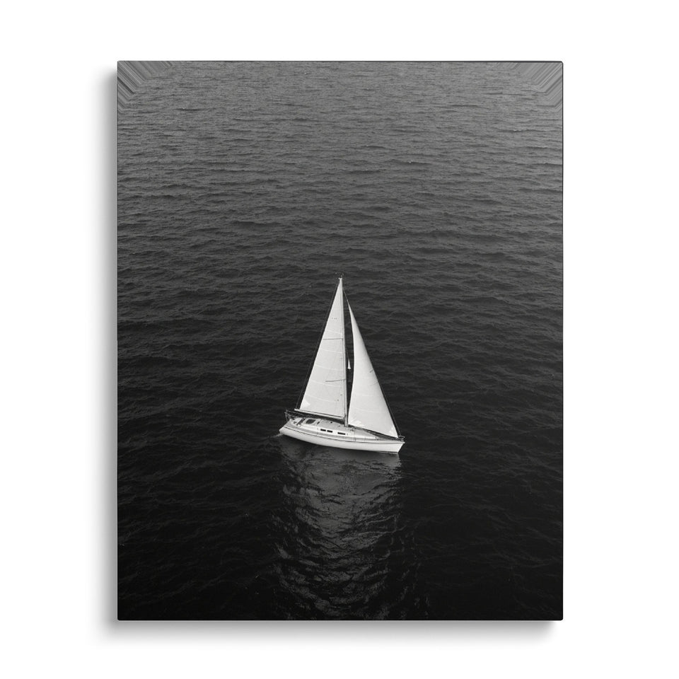 Toile Le Voilier vue de face sur fond blanc : photographie aérienne noir et blanc d’un voilier blanc seul sur une mer sombre