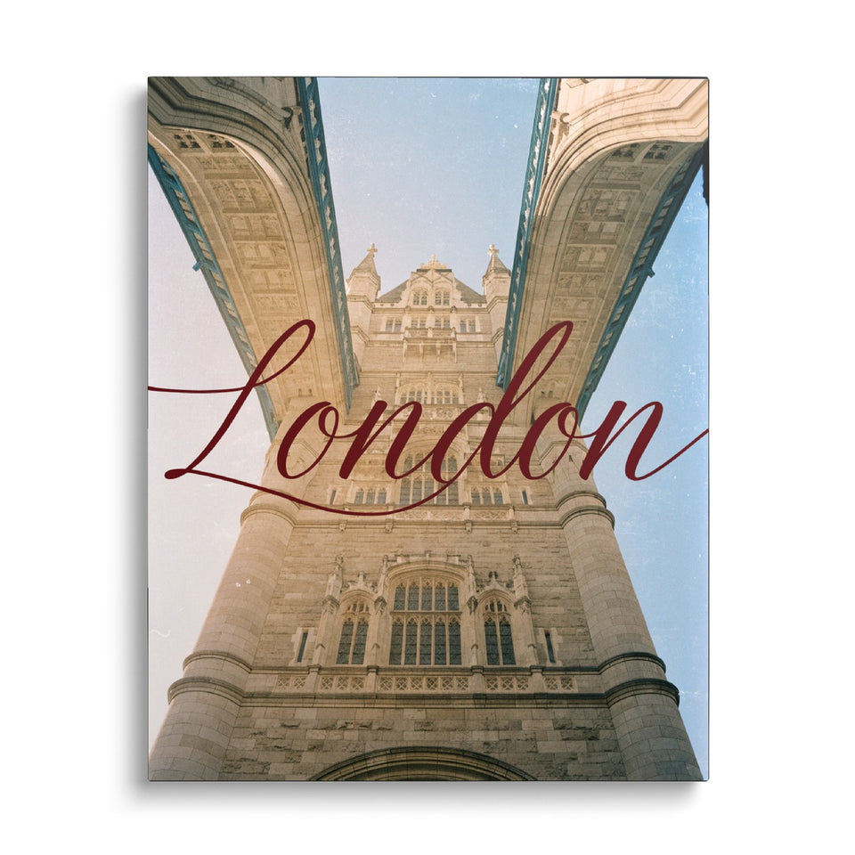 Toile London vue de face sur fond blanc : photographie en contre-plongée d’un pont londonien à tours de pierre, avec « London » en cursive bordeaux