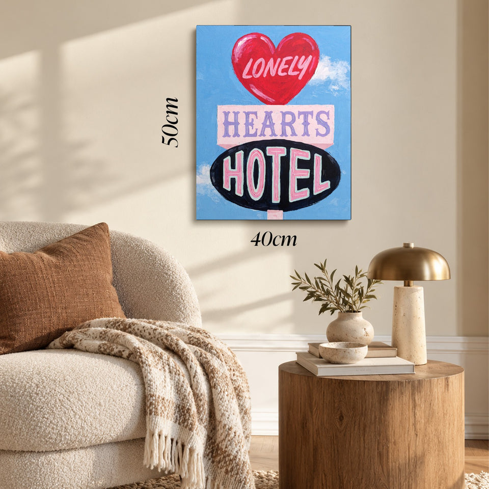 Toile Lonely Hearts Hotel accrochée dans un salon au-dessus d’un canapé, avec ses cotes 40 × 50 cm