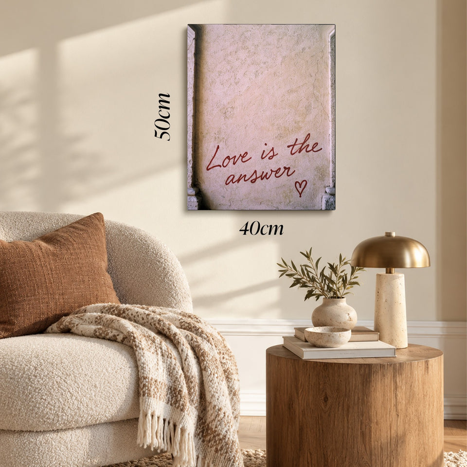 Toile Love Is the Answer accrochée dans un salon au-dessus d’un canapé, avec ses cotes 40 × 50 cm