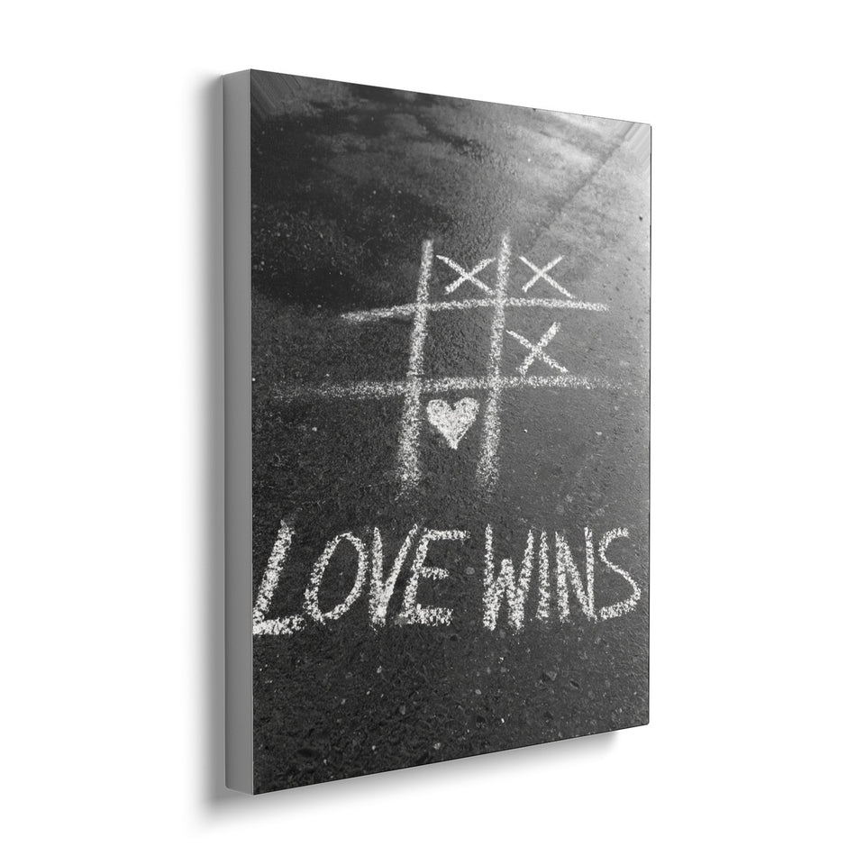 Toile Love Wins 40 × 50 cm, vue de trois quarts avec tranche blanche : photographie noir et blanc d’un morpion tracé à la craie sur le bitume, gagné par un cœur, avec « Love wins »