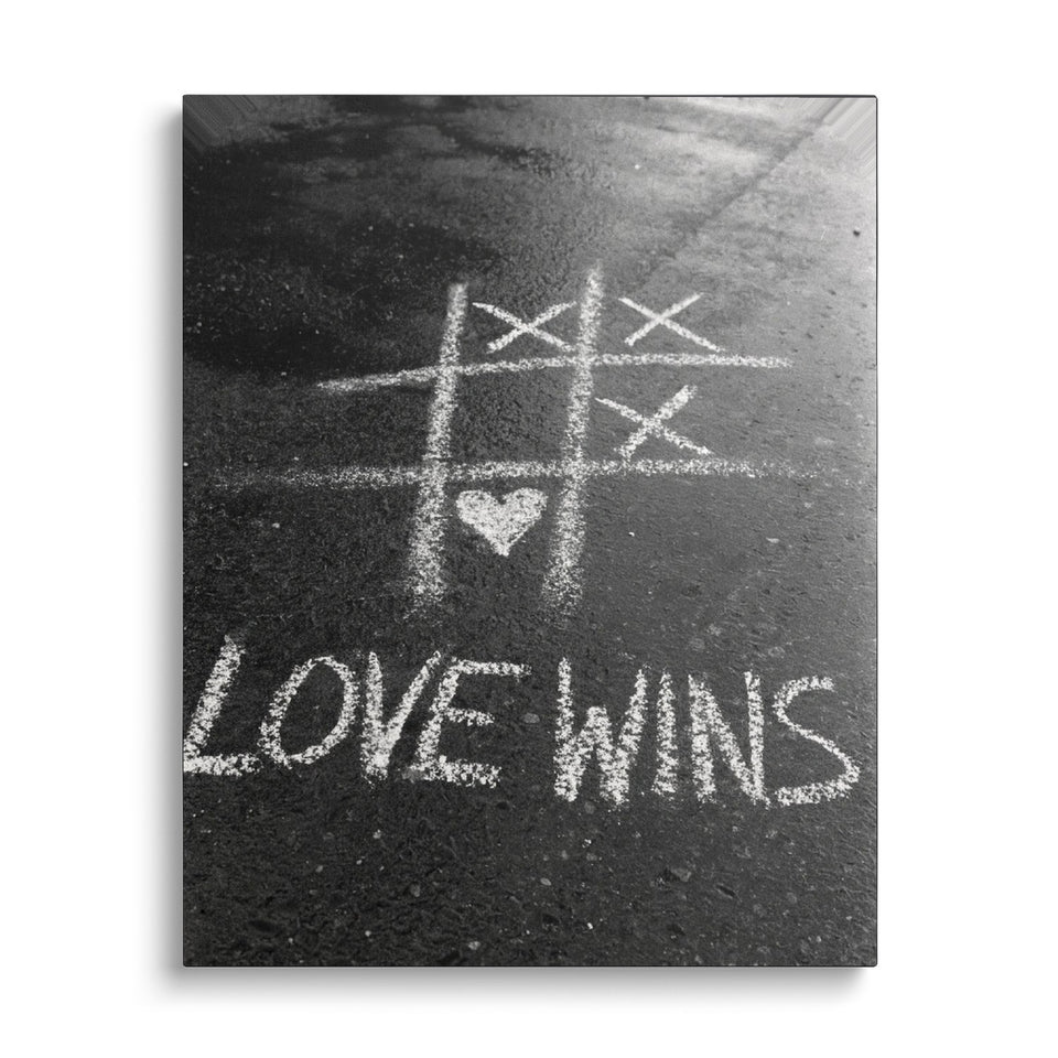 Toile Love Wins vue de face sur fond blanc : photographie noir et blanc d’un morpion tracé à la craie sur le bitume, gagné par un cœur, avec « Love wins »