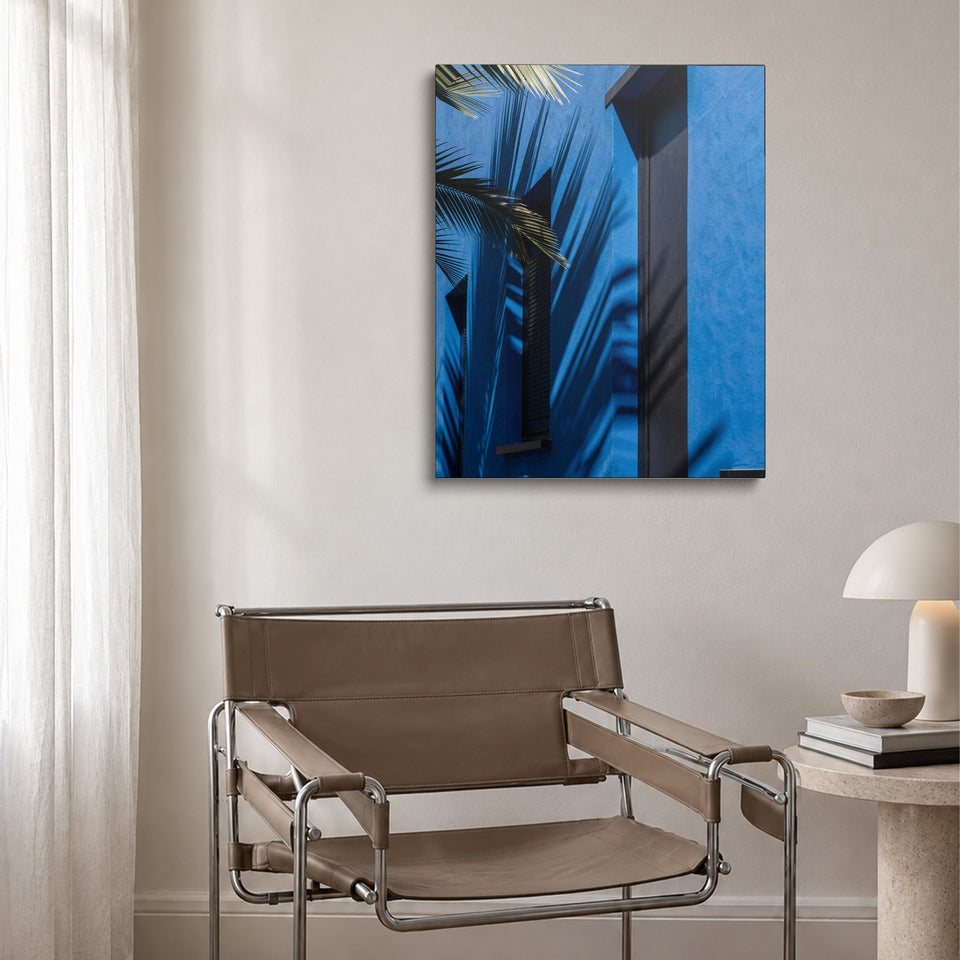 Toile Ombre Bleue accrochée au-dessus d’un fauteuil en cuir et acier