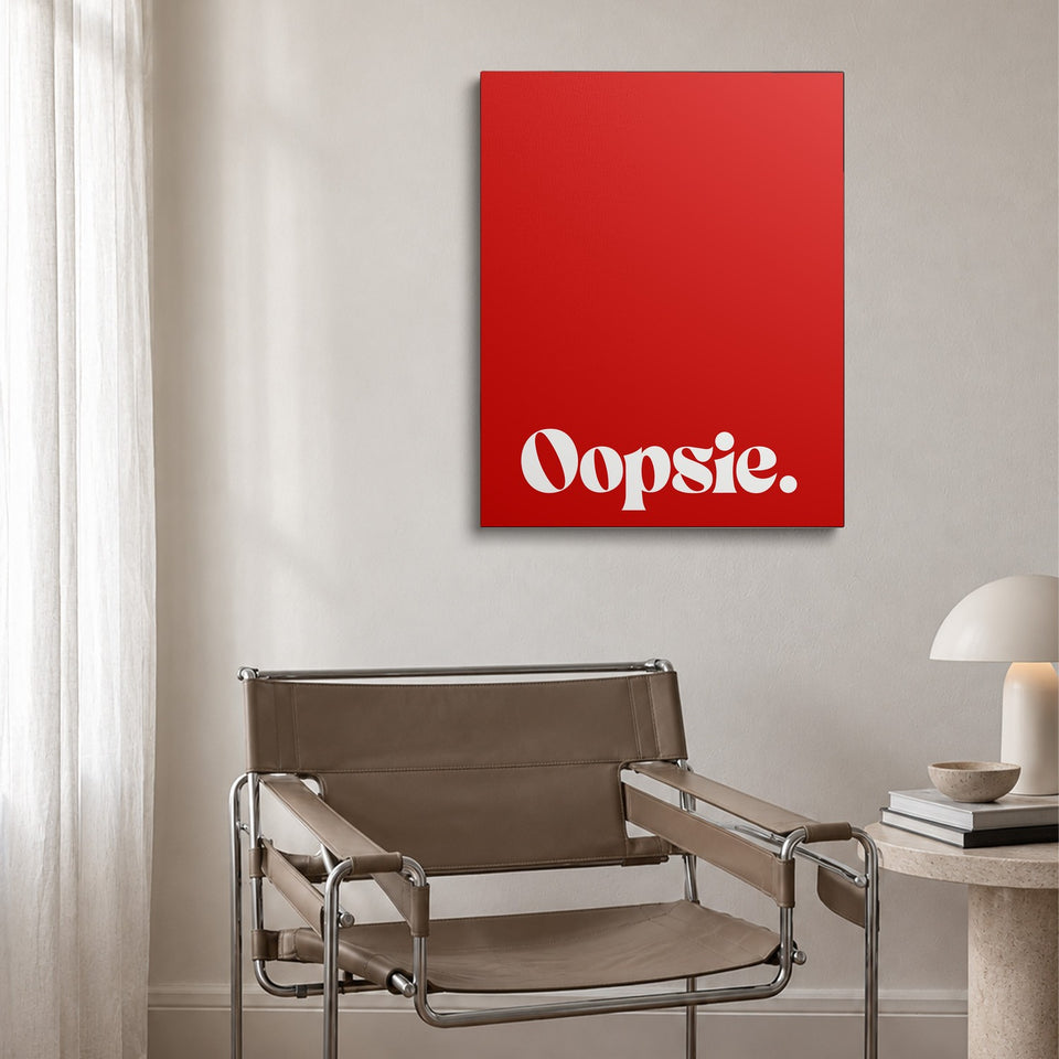 Toile Oopsie accrochée au-dessus d’un fauteuil en cuir et acier