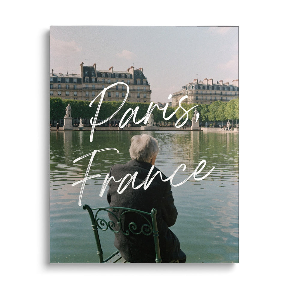 Toile Paris, France vue de face sur fond blanc : photographie d’un homme assis de dos sur une chaise verte au bord d’un bassin parisien, avec « Paris, France » en écriture manuscrite
