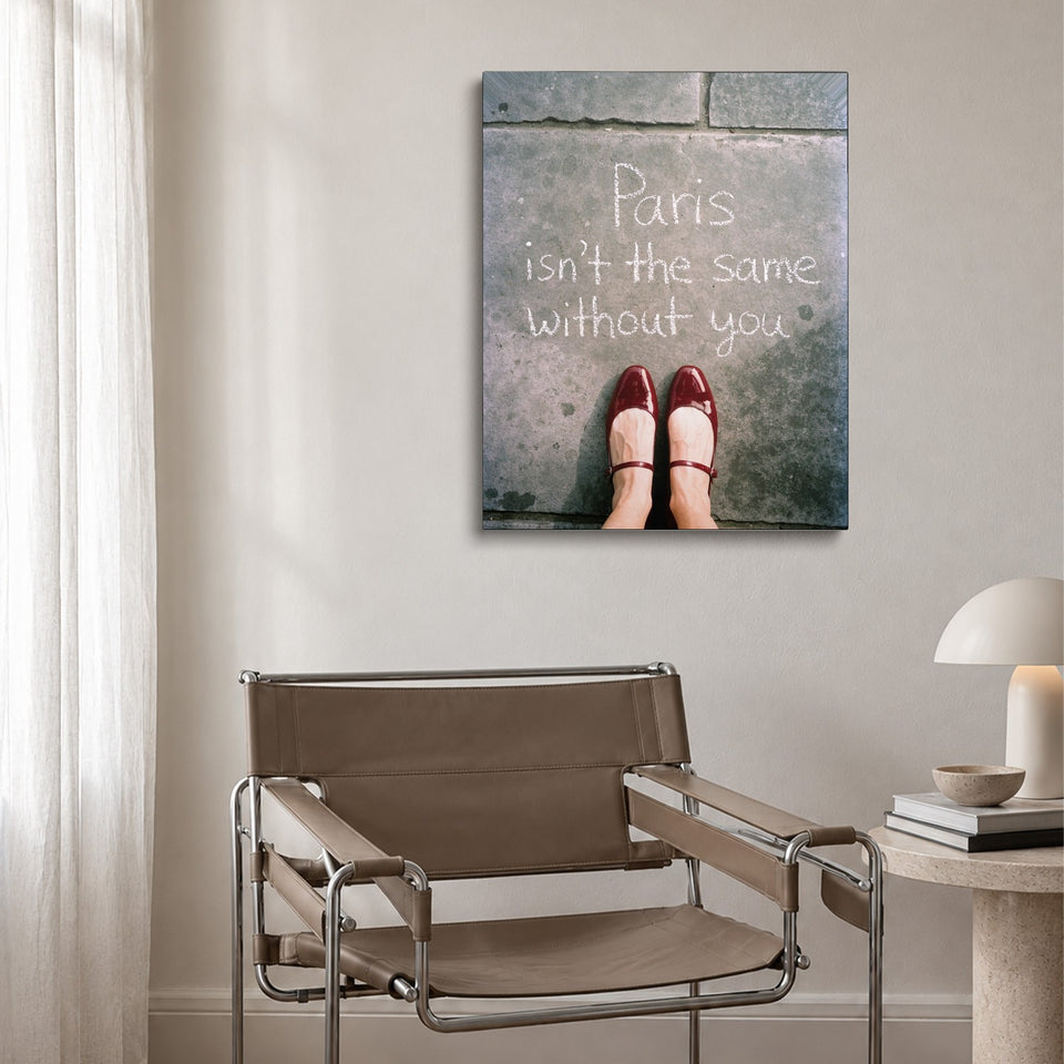 Toile Paris Sans Toi accrochée au-dessus d’un fauteuil en cuir et acier