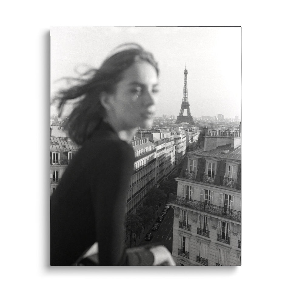 Toile Parisienne vue de face sur fond blanc : photographie noir et blanc d’une femme de profil, cheveux au vent, devant les toits de Paris et la tour Eiffel