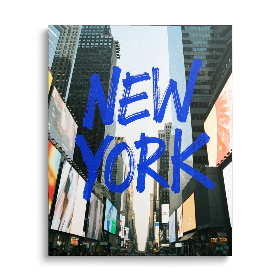 Toile Times Square vue de face sur fond blanc : mots « New York » peints au pinceau bleu sur une photographie de gratte-ciel et d’écrans publicitaires