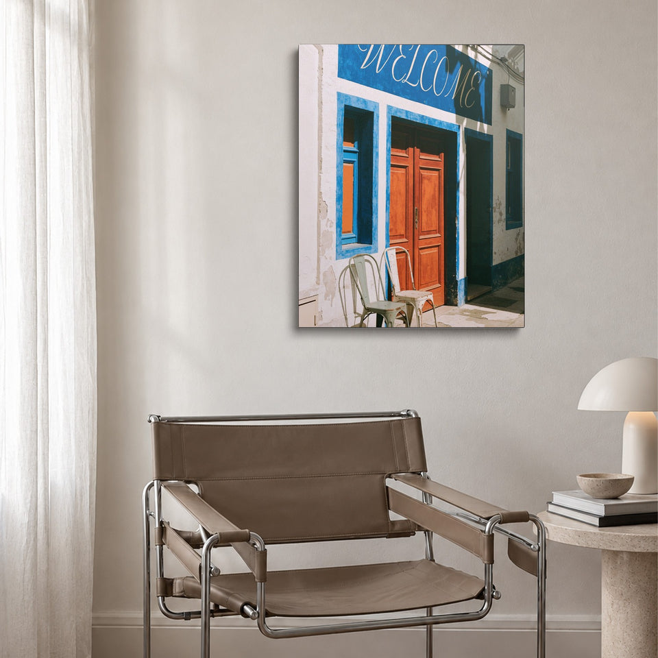 Toile Welcome accrochée au-dessus d’un fauteuil en cuir et acier