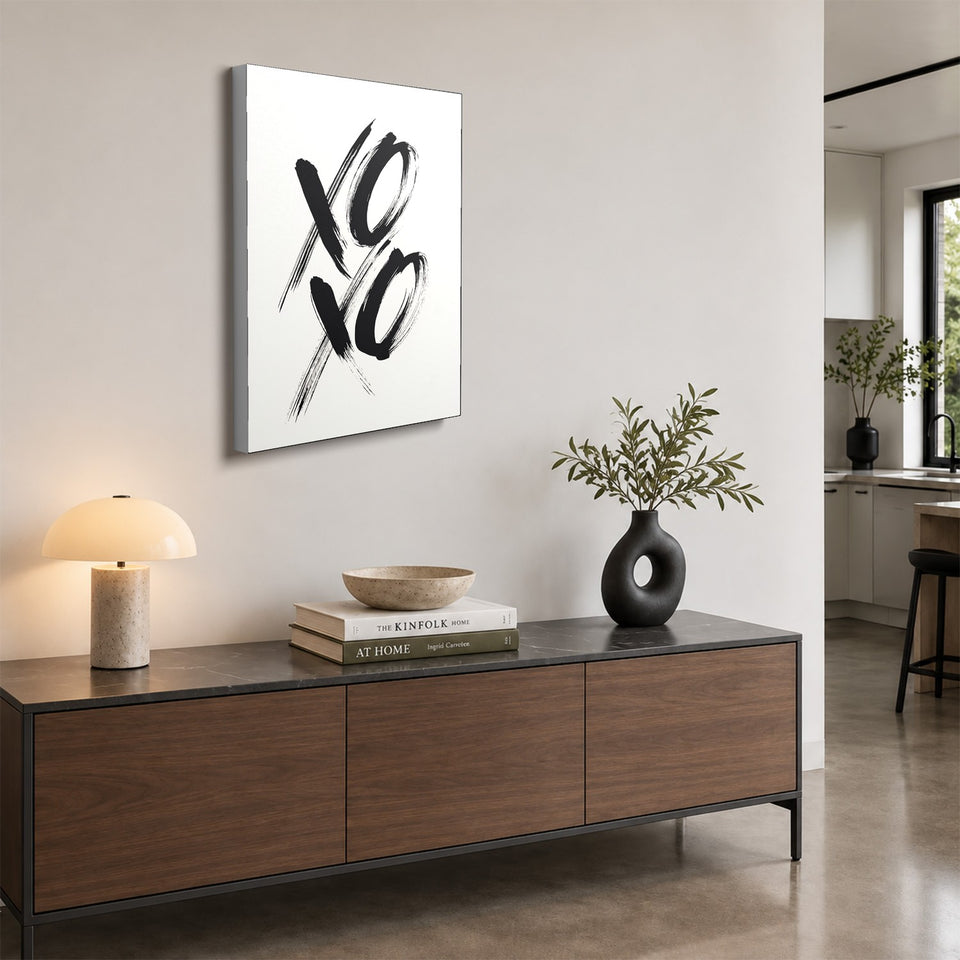 Toile XOXO accrochée au-dessus d’un buffet en noyer