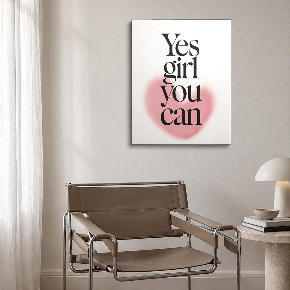 Toile Yes Girl You Can accrochée au-dessus d’un fauteuil en cuir et acier